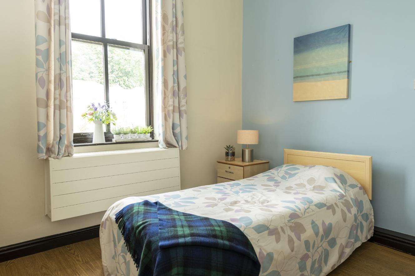 a single bed in a room with light blue walls